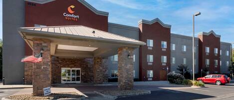 A Comfort Suites hotel with a brick facade, a covered entrance, and a parking lot.