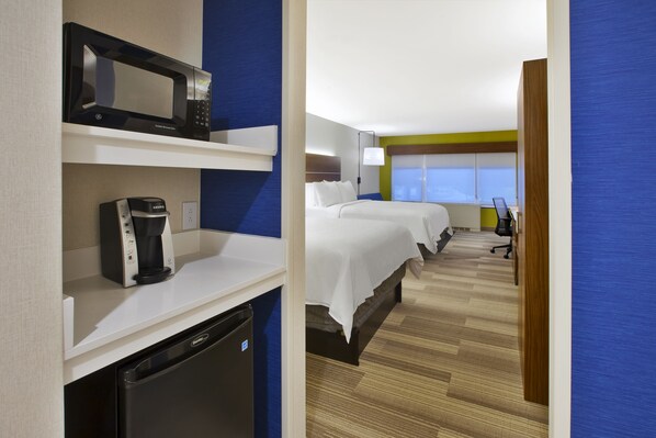 A hotel room with a microwave, coffee maker, and a compact refrigerator. There are two beds with white linens, a desk with a chair, and a window with blinds. - Holiday Inn Express Hotel & Suites Rochester - Victor by IHG (Victor)