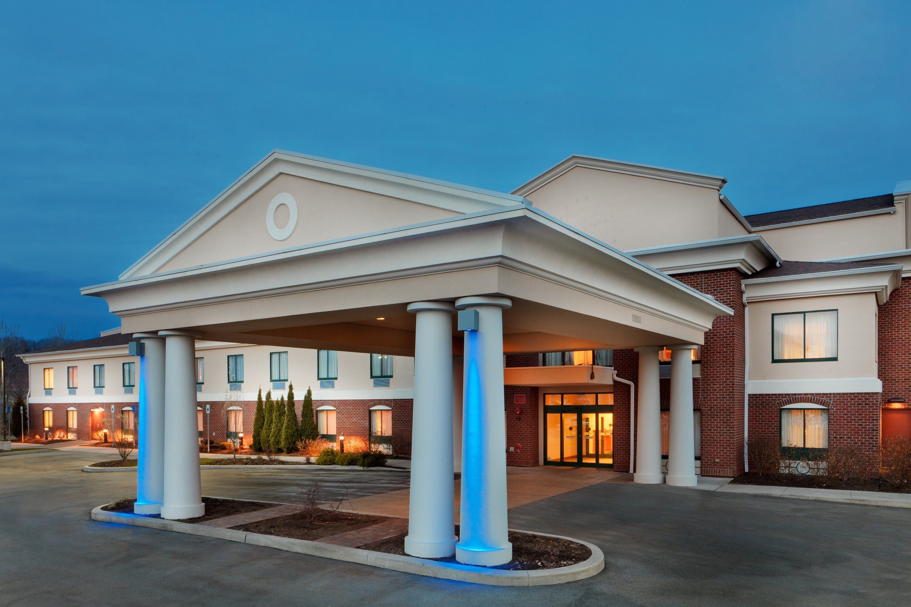A hotel with a covered entrance, multiple windows, and a brick facade.