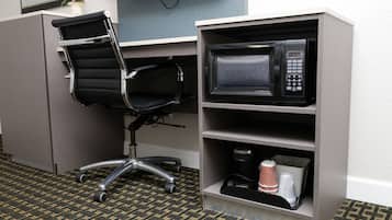 A kitchenette with a microwave, a coffee maker, and a chair.