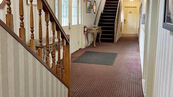 A hallway with a carpeted floor, a wooden staircase, and a door marked '309'.