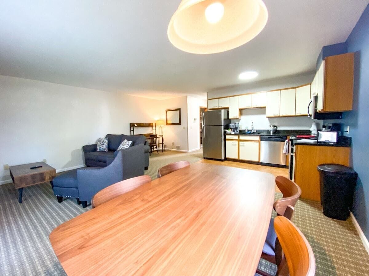 A compact living space with a dining area, kitchenette, and seating area.