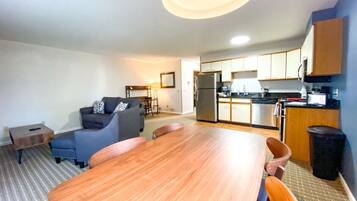 A compact living space with a dining area, kitchenette, and seating area.