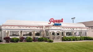 A diner with a retro design, featuring a prominent red and blue sign, large windows, and a flat roof.