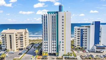 A coastal cityscape with a beachfront, high-rise buildings, and a mix of residential and commercial structures. at Seaside Resort