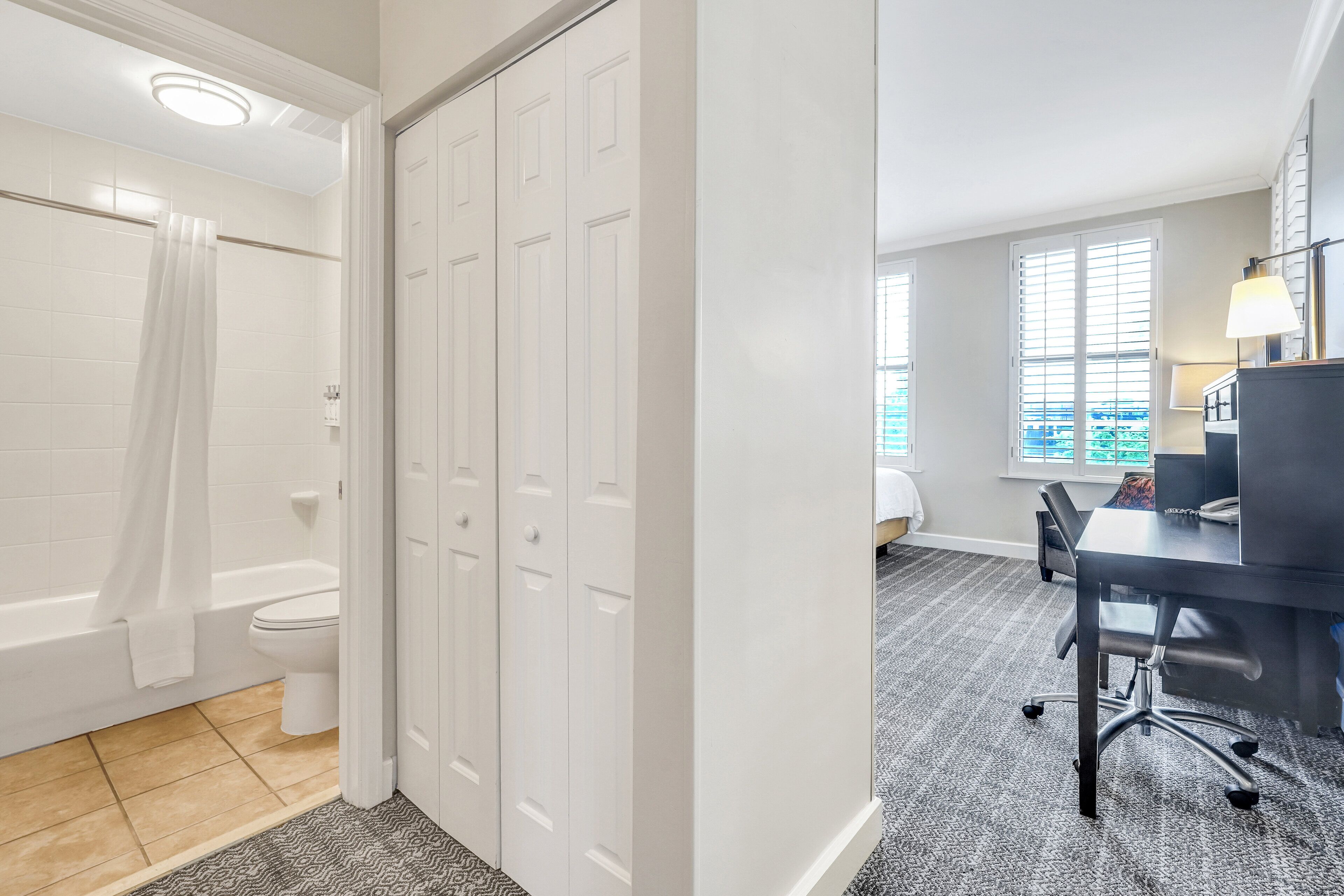 A bathroom with a bathtub, toilet, and a walk-in closet.