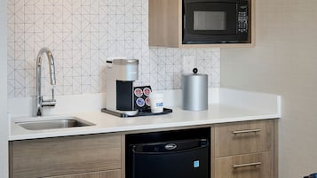 A compact kitchen with a microwave, coffee maker, and dishwasher.