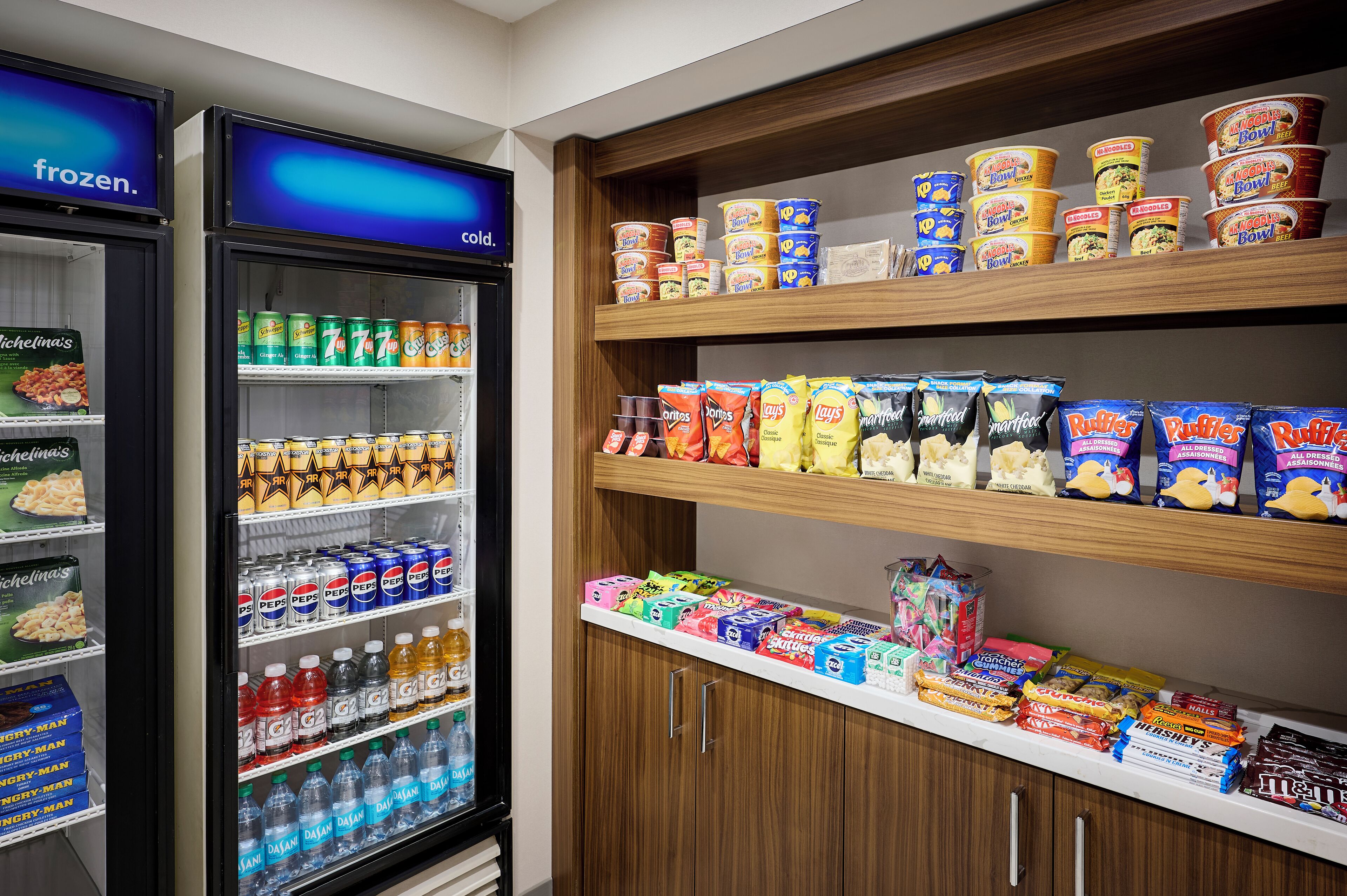 Una sección de snacks y bebidas con refrigerios, conservas y diferentes paquetes de comida.
