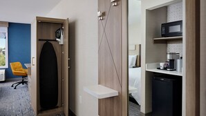 A hotel room with a large mirror, a bed, a small kitchenette, and a seating area with a yellow chair. - Holiday Inn Express and Suites Kitchener Southeast by IHG (Kitchener)