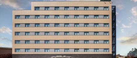 Un hotel de varios pisos con fachada plana, amplias ventanas y un cartel que indica que es un hotel Marriott.