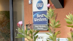 Entrada de un hotel con un cartel que dice "Best Western Hotel Nurnberg City West" y el número "6" sobre la puerta.