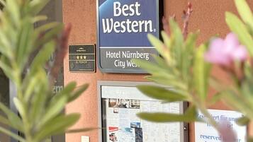 A hotel sign for Best Western Hotel Nurnberg City West, with a plaque indicating a superior rating.