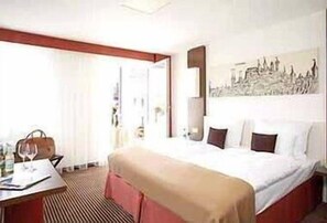 A hotel room with a bed, a desk with a chair, a handbag, and a wine glass. - Best Western Hotel Nuernberg City West (Nuremberg)