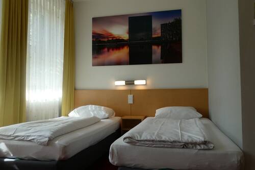 Habitación con 2 camas individuales | Escritorio, tabla de planchar con plancha, ropa de cama