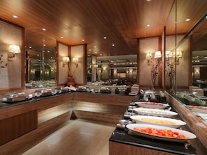 Montaje de bufé con diferentes alimentos y un espejo que refleja la sala.