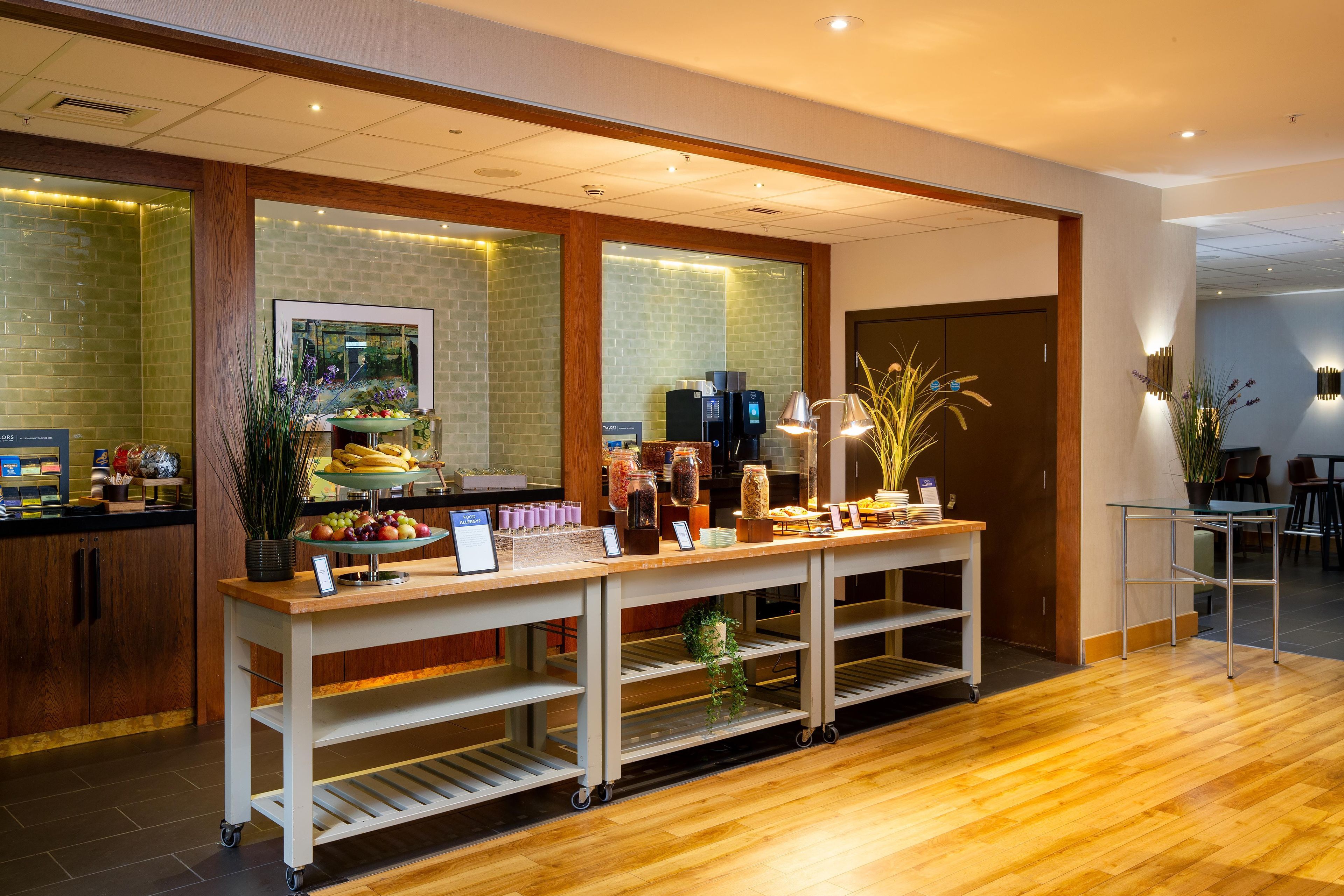 A buffet area with a variety of food items, a coffee station, and a seating area with tables and chairs.