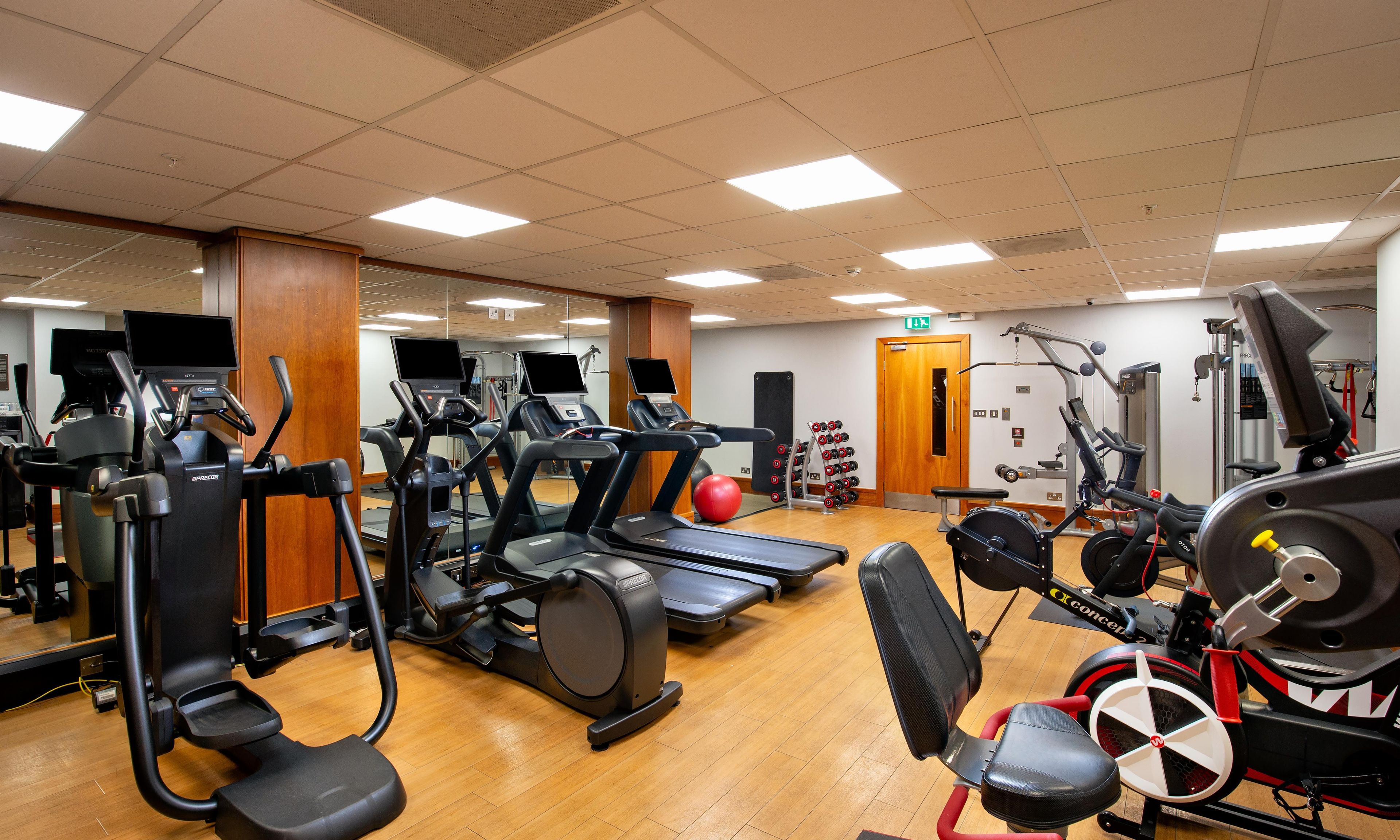 A gym with treadmills, elliptical machines, and weight equipment.