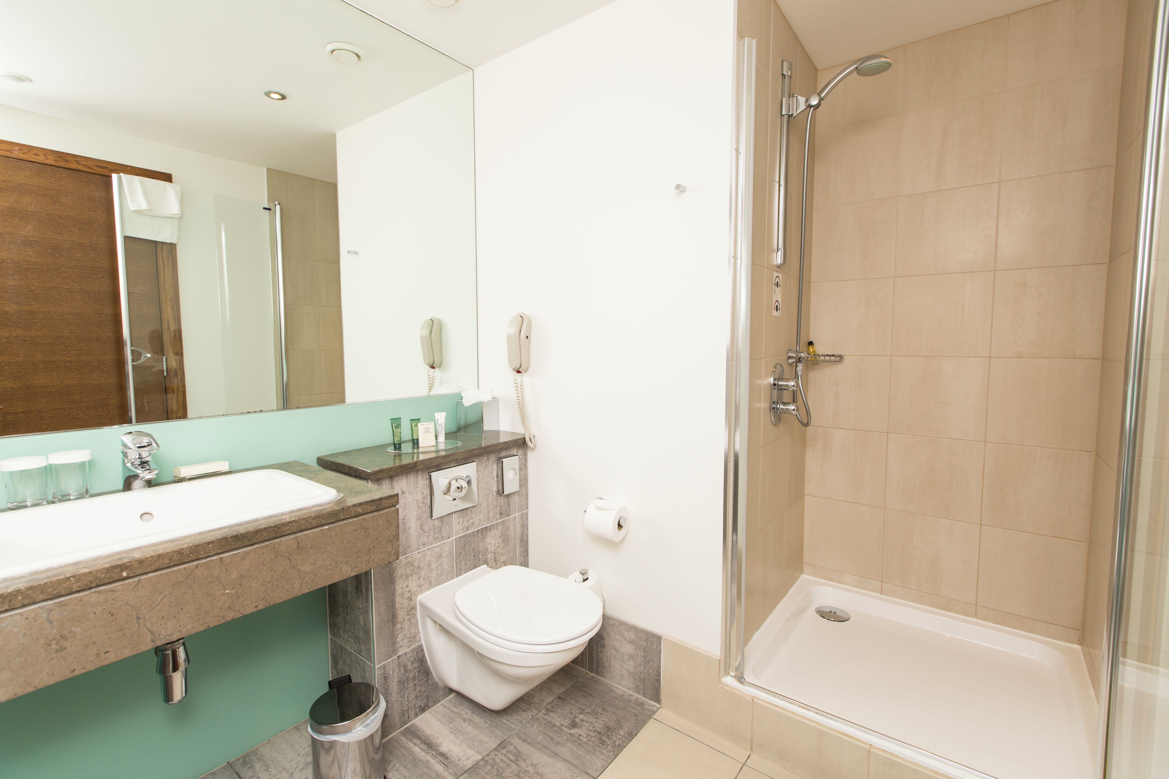 Un baño moderno con lavamanos, inodoro y ducha.