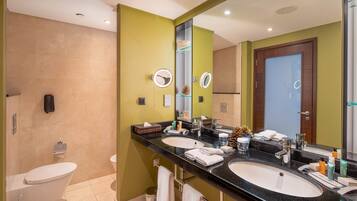 Un baño moderno con dos lavamanos, un inodoro y un espejo grande.