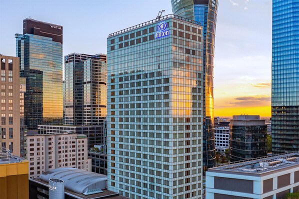 A modern hotel with a prominent Hilton sign, surrounded by other high-rise buildings. - Hilton Warsaw City (Warsaw)