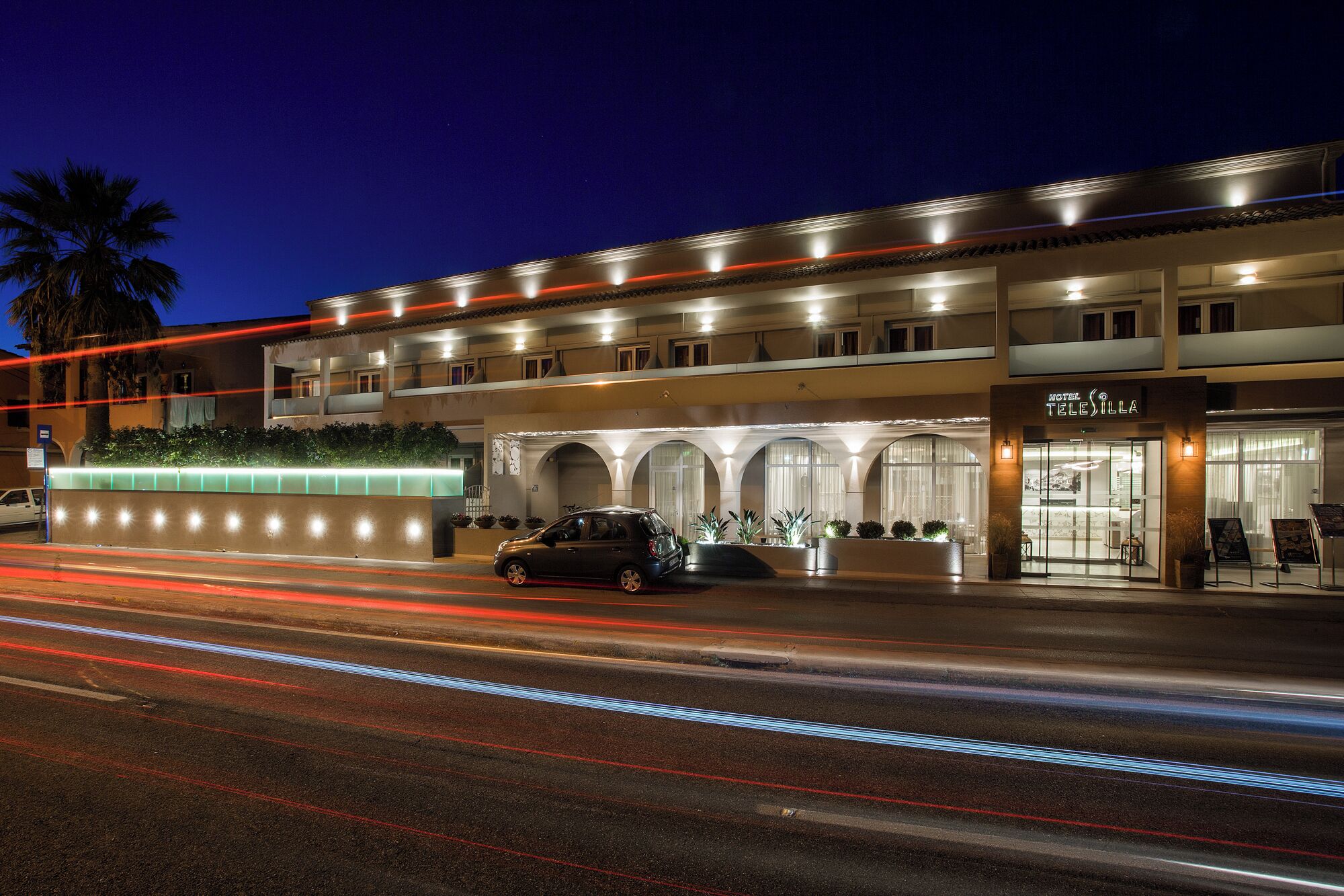 A hotel with a modern facade, multiple balconies, and a well-lit entrance.