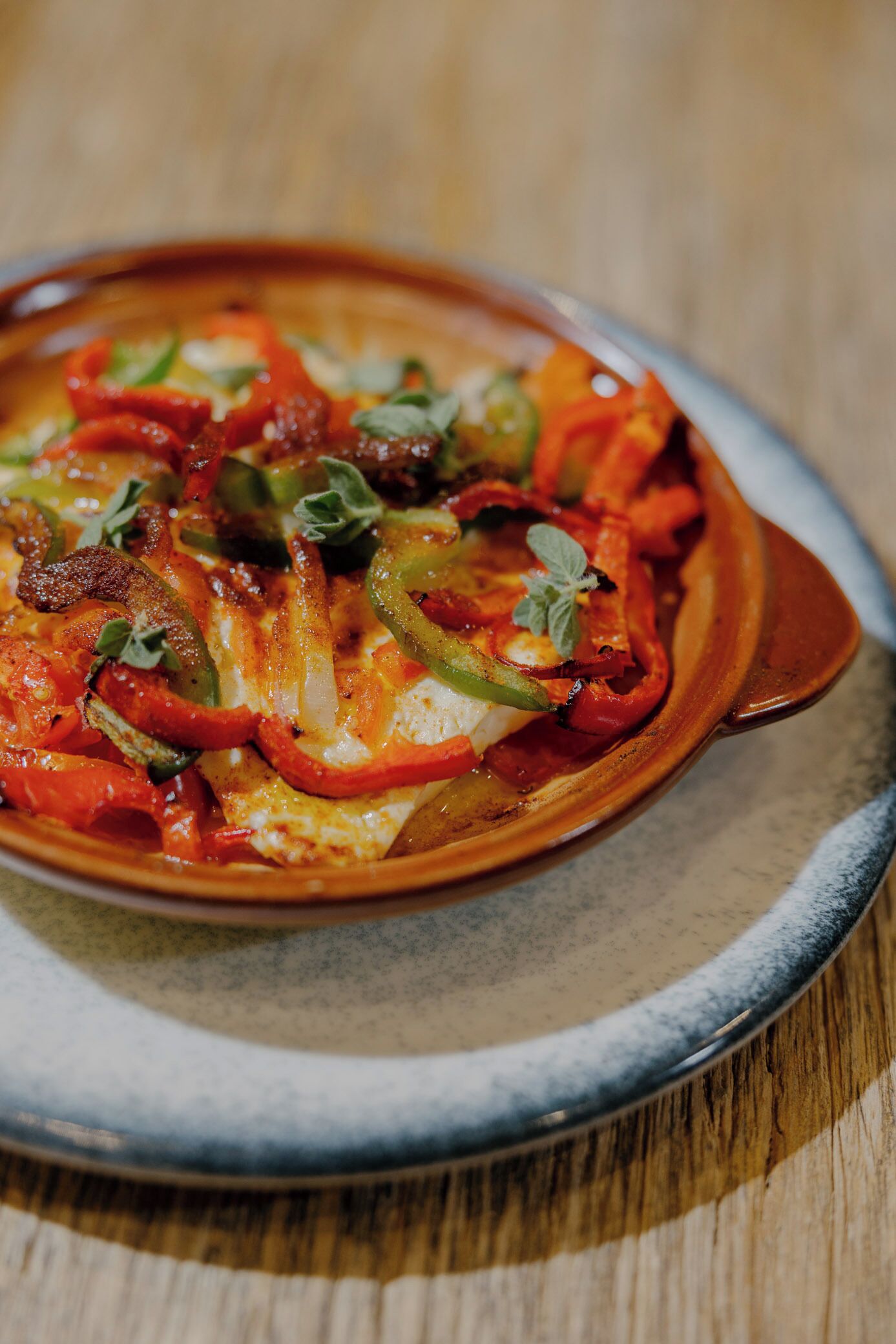 A dish with bell peppers and cheese on a ceramic plate.