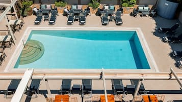 Una piscina al aire libre de temporada, sombrillas