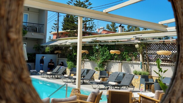 A poolside area with lounge chairs and a view through a circular mirror. - Telesilla Hotel (Corfu)