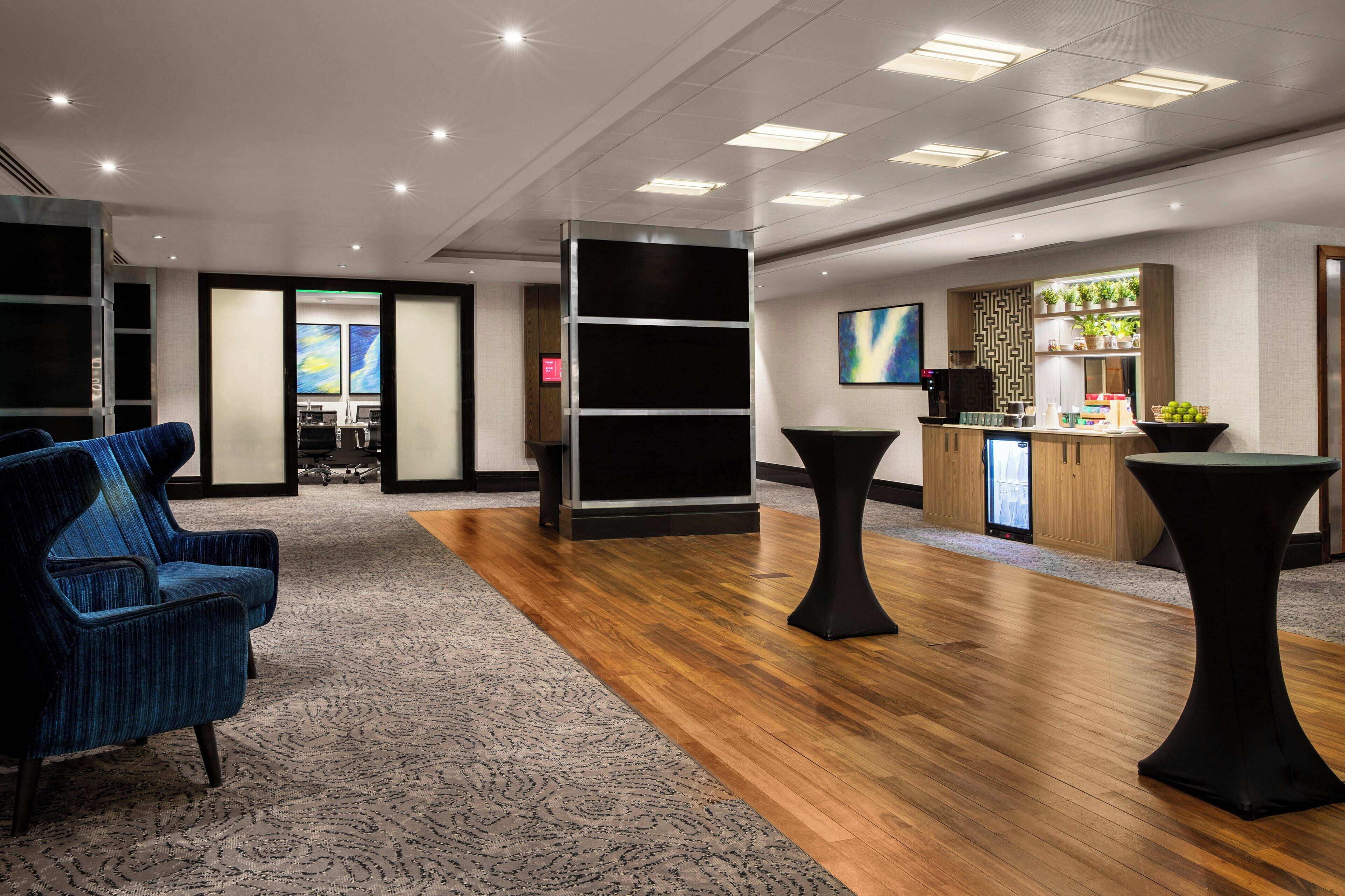 Eine moderne Lobby mit einer Rezeption, einer Sitzgelegenheit und einer Bar.