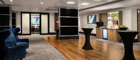 Eine moderne Lobby mit einer Rezeption, einer Sitzgelegenheit und einer Bar.
