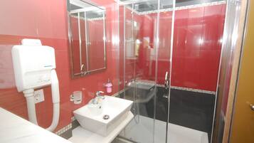 A bathroom with a glass-enclosed shower, a sink, and a mirror.