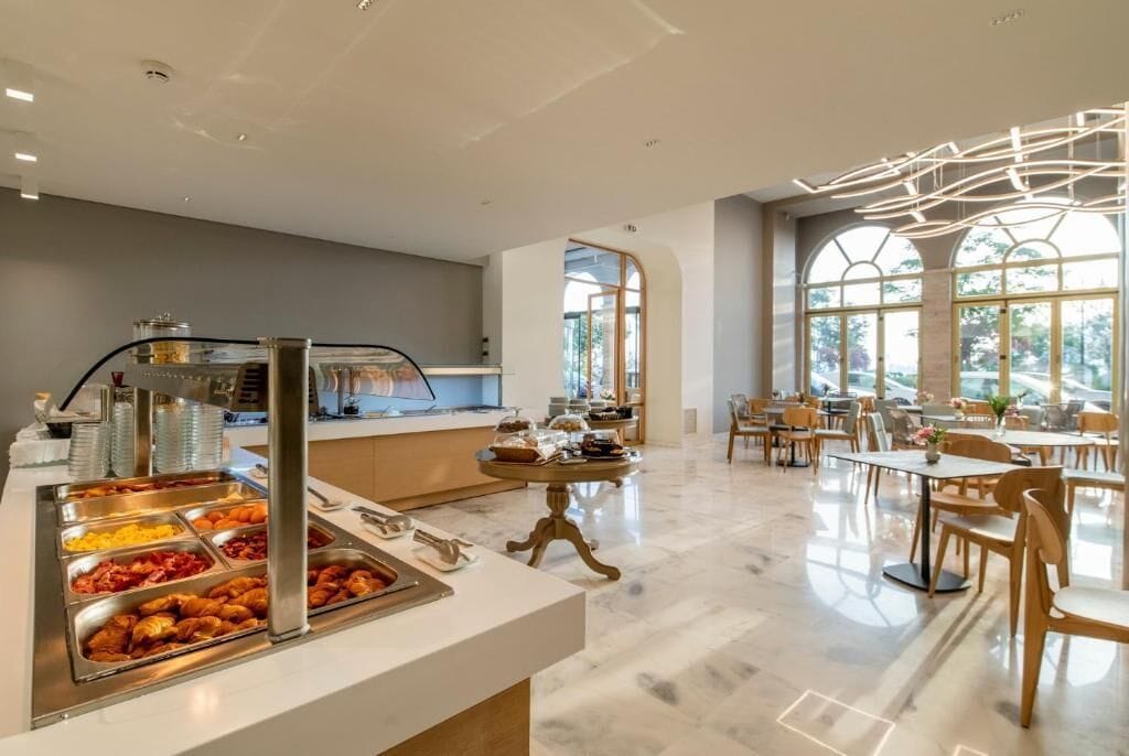 Ein moderner Essbereich mit Buffet, Marmorböden und großen Fenstern.