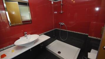A bathroom with a white sink, a shower, and a toilet.