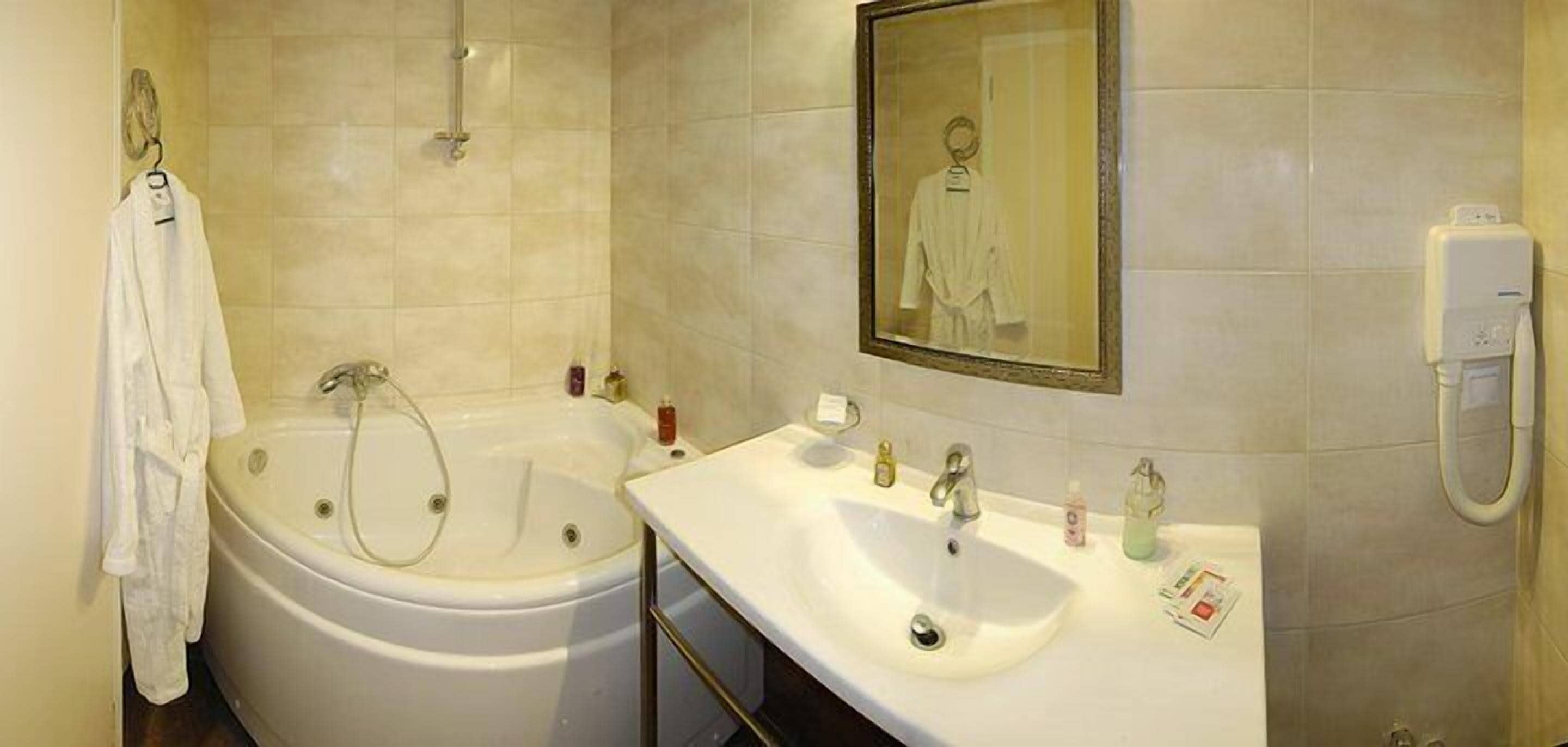 A bathroom with a bathtub, a sink, and a mirror.