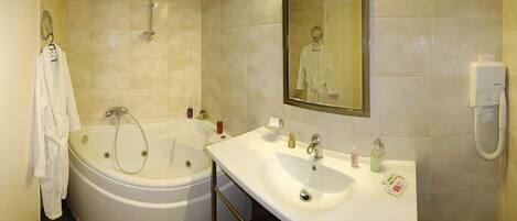 A bathroom with a bathtub, a sink, and a mirror.