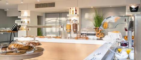A modern breakfast buffet with various food items and a coffee station.