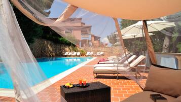 Seasonal outdoor pool, open 10:00 AM to 7:00 PM, pool umbrellas