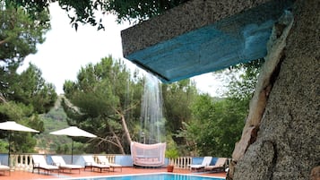 Una piscina al aire libre de temporada, sombrillas