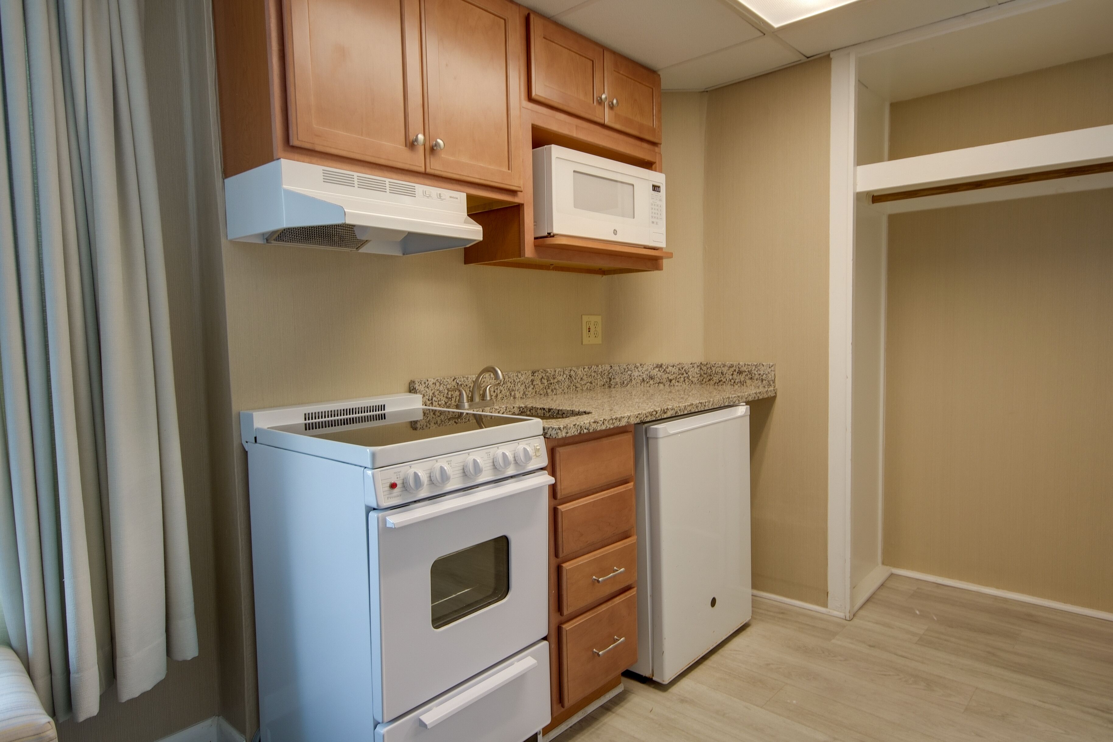 A kitchen with wooden cabinets, a microwave, a stove, and a dishwasher.