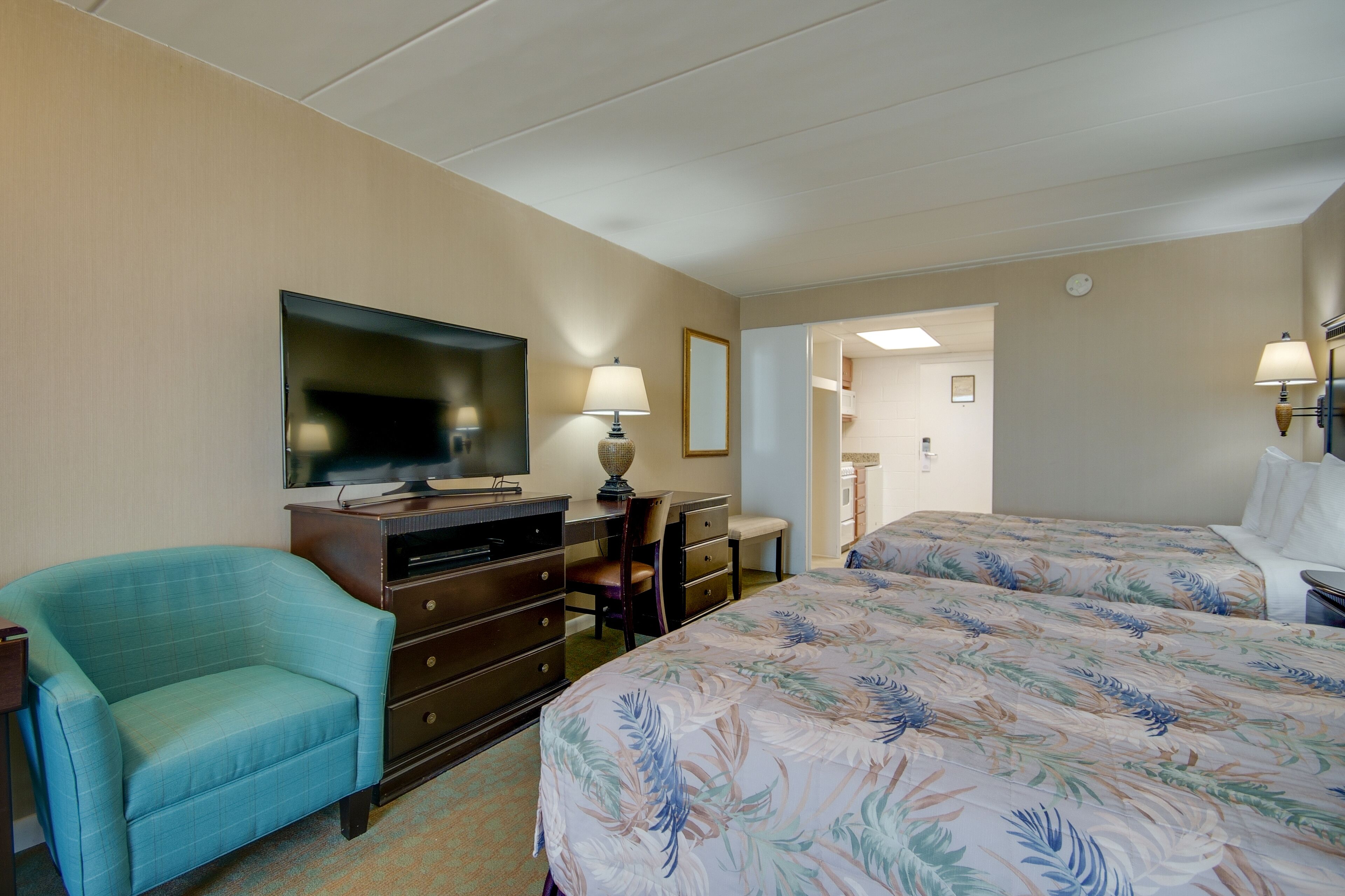 Une chambre d’hôtel équipée d’un lit, d’un bureau, d’une chaise, d’une télévision et d’une lampe.