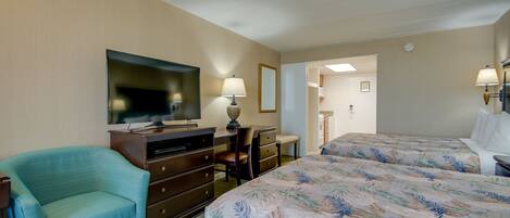 Ein Hotelzimmer mit Bett, Schreibtisch, Stuhl, Fernseher und Lampe.