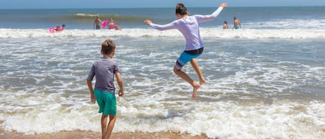 A beach scene with people enjoying the waves.