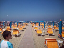 Una playa cerca, camas de playa, sillas reclinables de playa, sombrillas