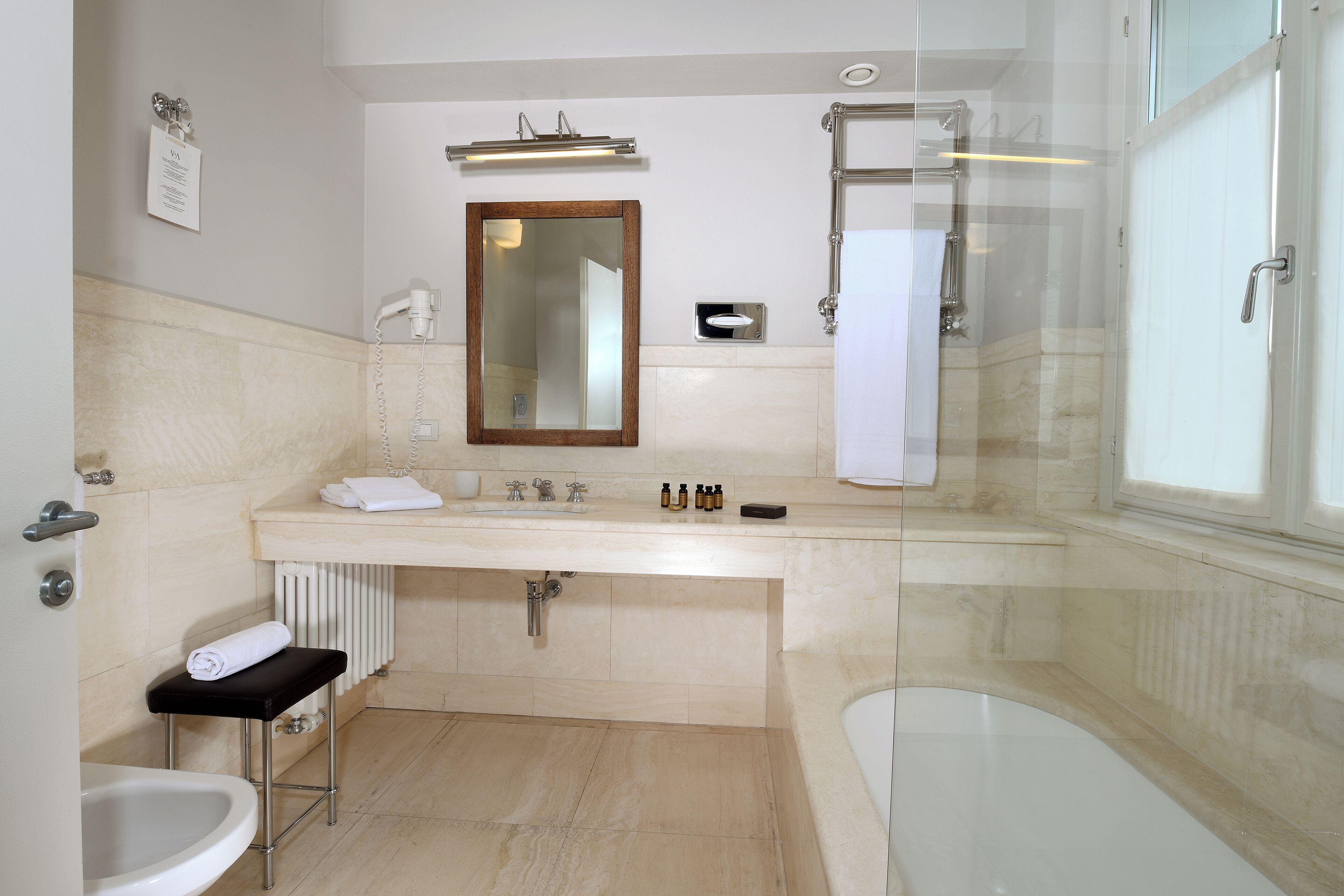 Un bagno moderno con vasca, lavabo con specchio e cabina doccia in vetro.