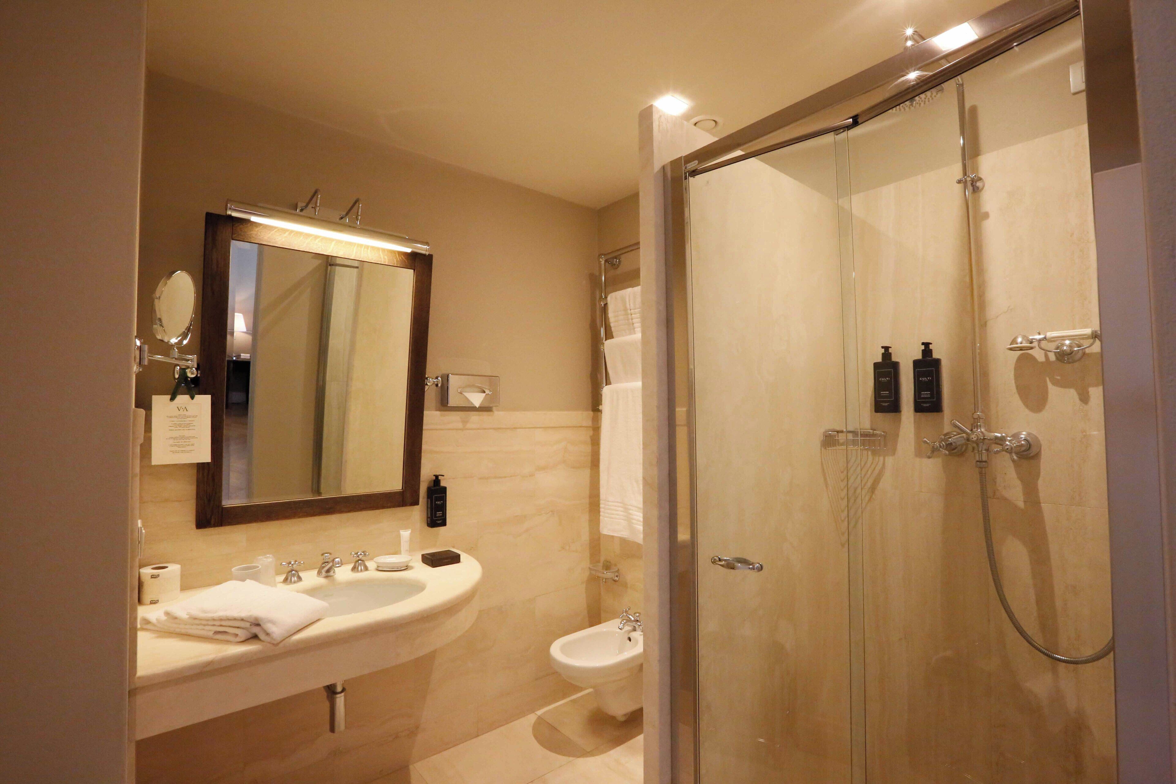 A modern bathroom with a sink, mirror, and shower.