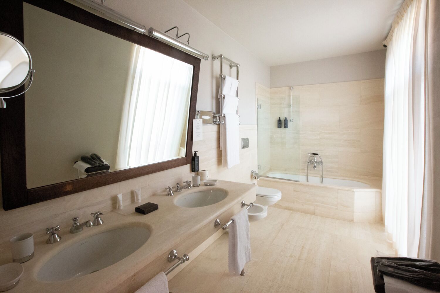 Une salle de bain moderne avec deux lavabos, un grand miroir, une douche et des toilettes.