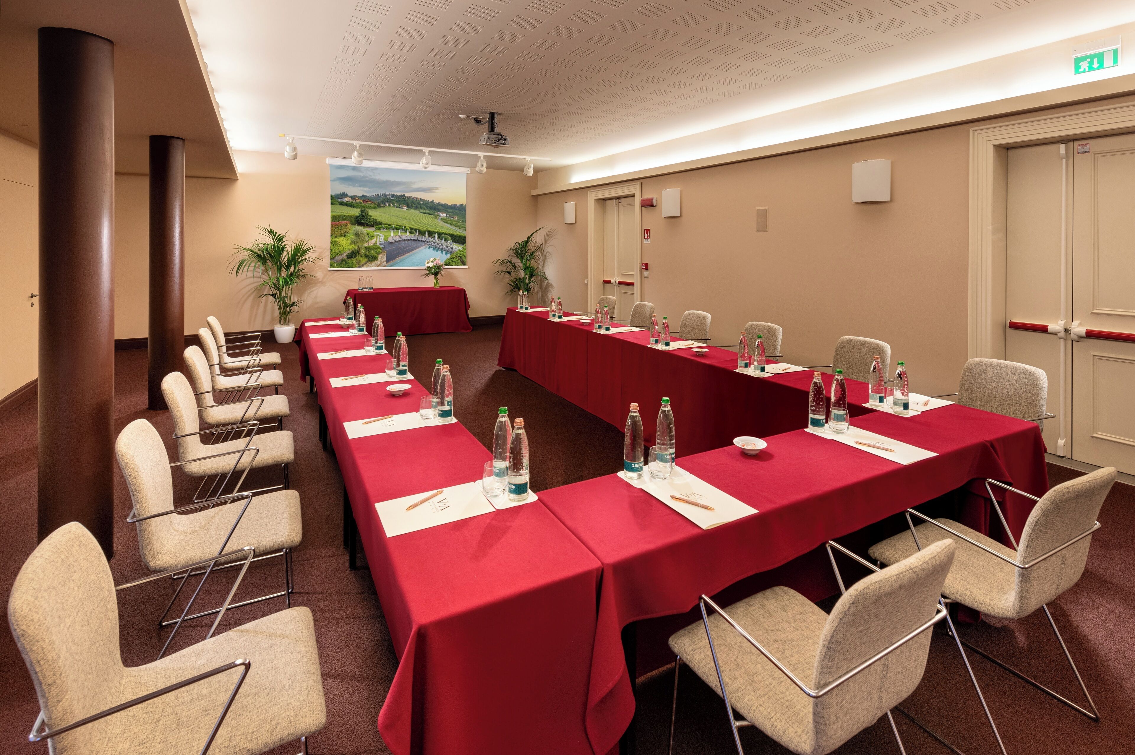 Ein Konferenzraum mit langem Tisch, Stühlen und einem großen Fenster mit Blick auf eine Landschaft.