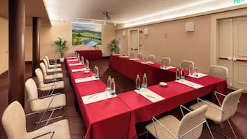 Ein Konferenzraum mit langem Tisch, Stühlen und einem großen Fenster mit Blick auf eine Landschaft.