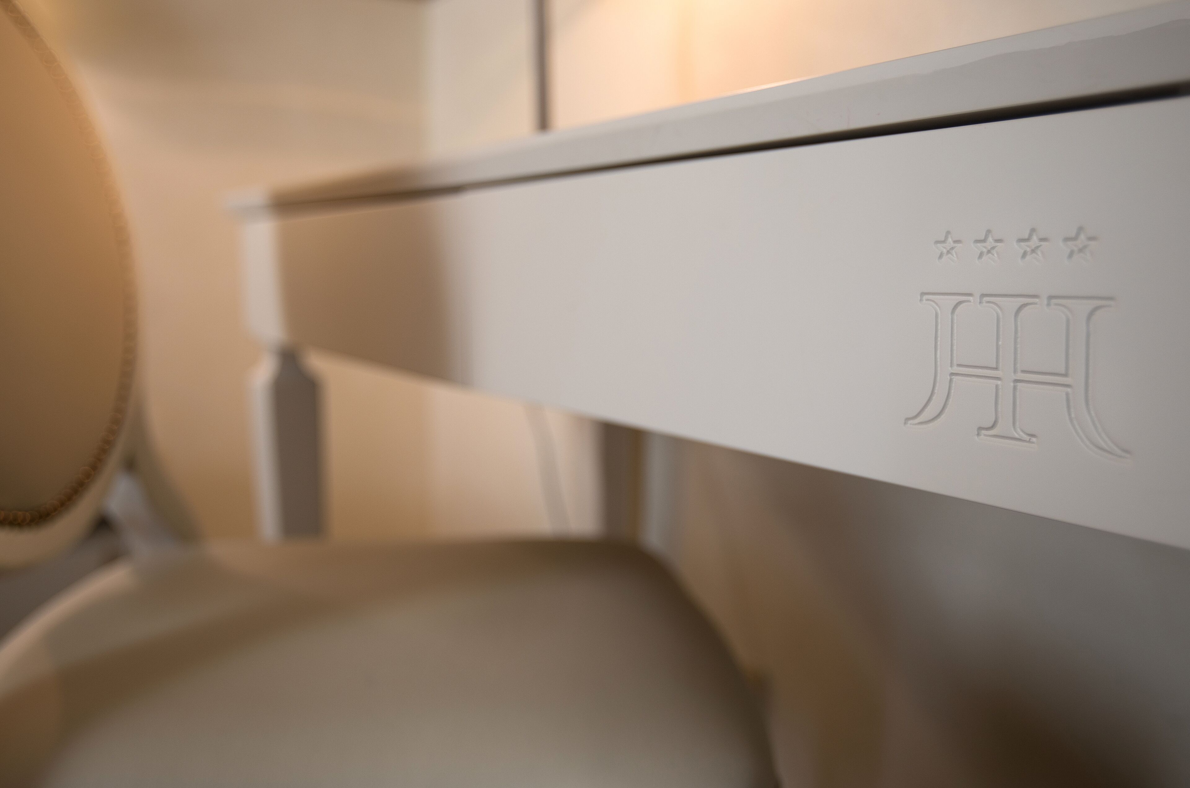 A close-up of a white piece of furniture with embossed text and a logo.