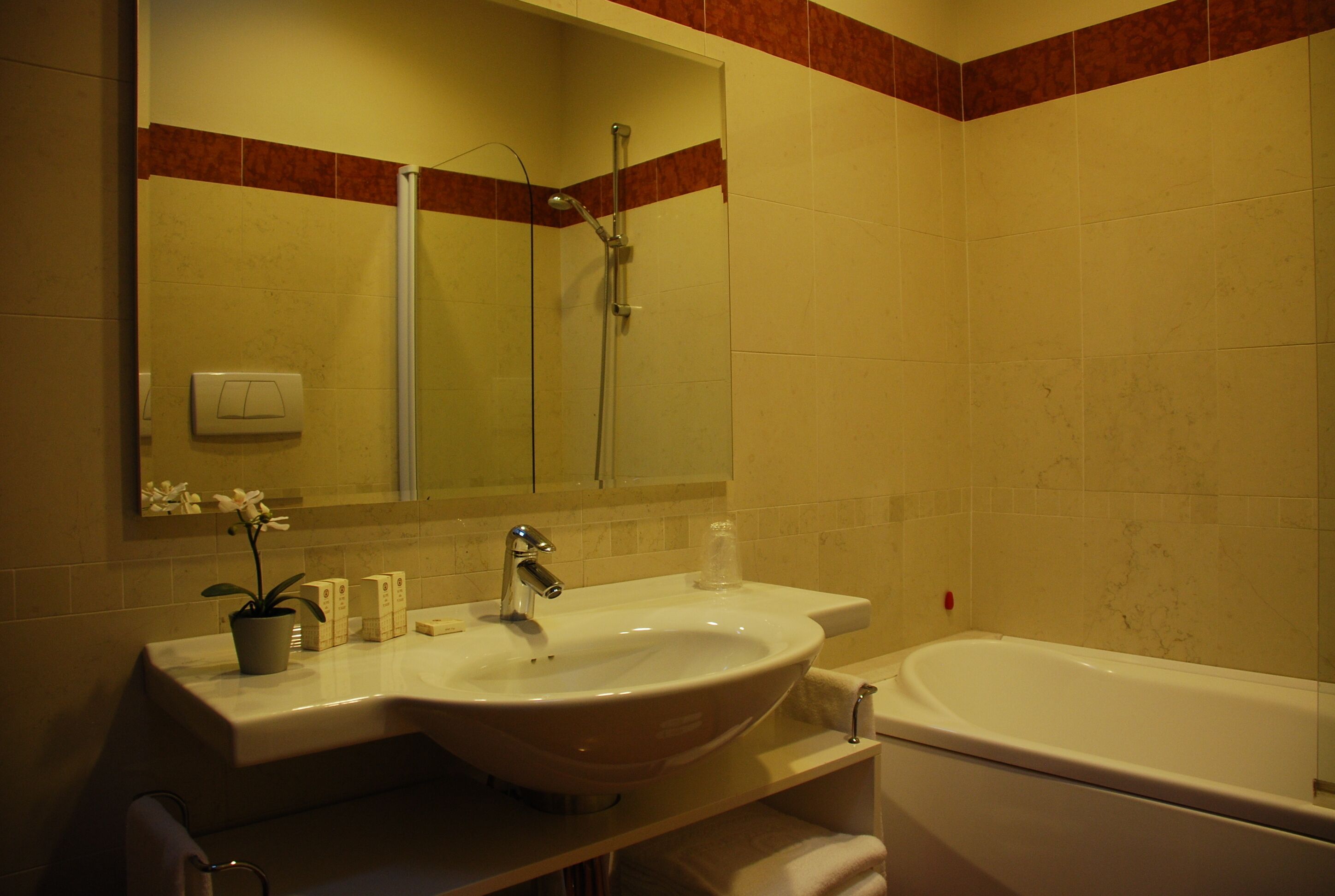 Un baño con lavamanos, espejo, ducha y bañera.